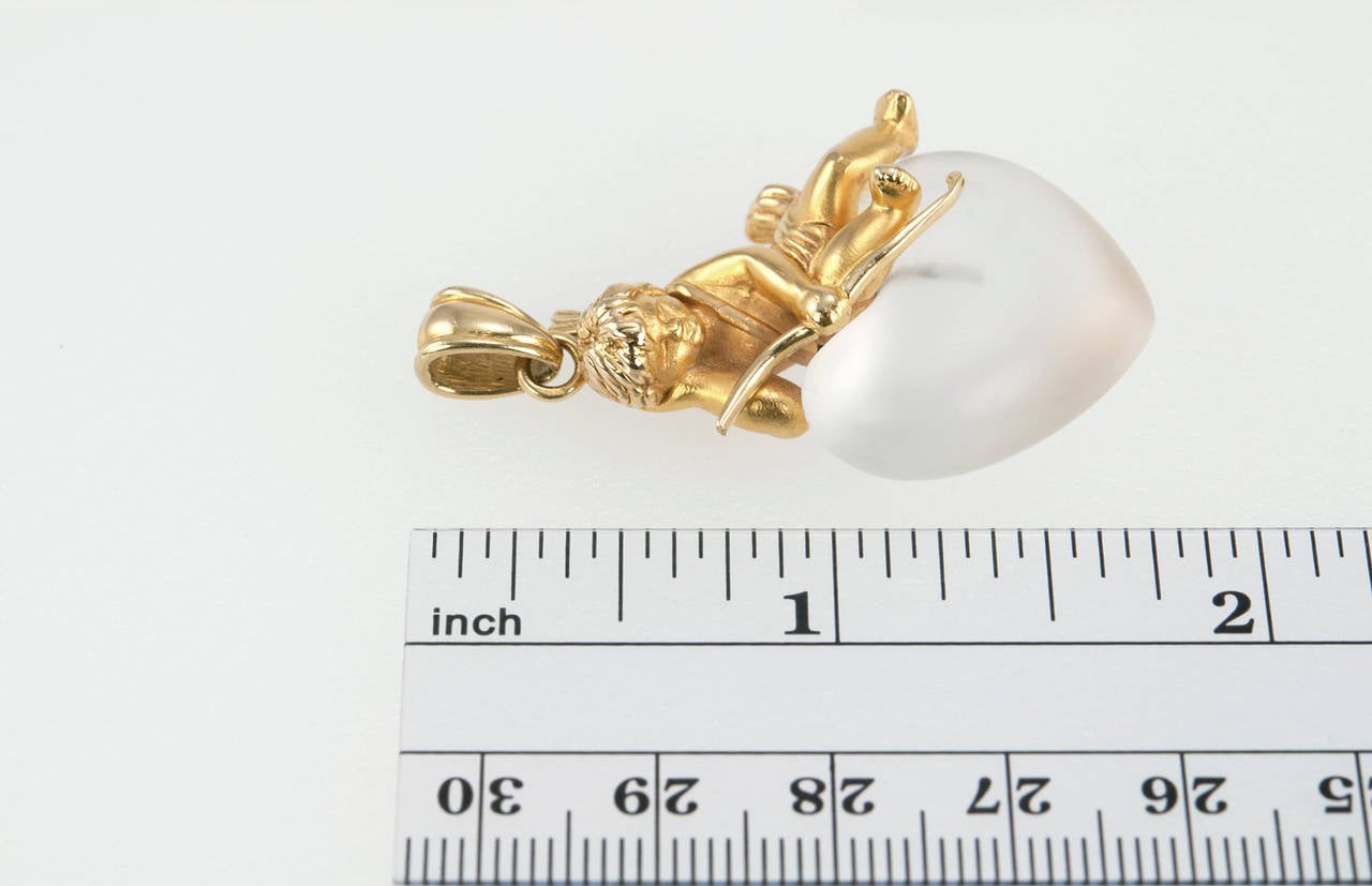 Carrera Y Carrera 18 karat gold cupid with arrows sitting on a heart made of rock crystal- a very sweet pendant! 

Pendant measures approximately 1.10 inches in width; 1.85 inches in length; 0.60 inches in depth.