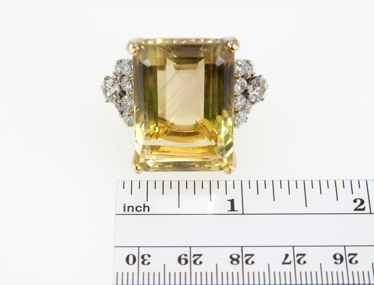 A very stylish citrine and diamond cocktail ring. The citrine is approximately 17.5 carats and is flanked by two larger diamonds on each side, approximately 0.60 carats each, along with twelve smaller round diamonds that approximately total 1 carat