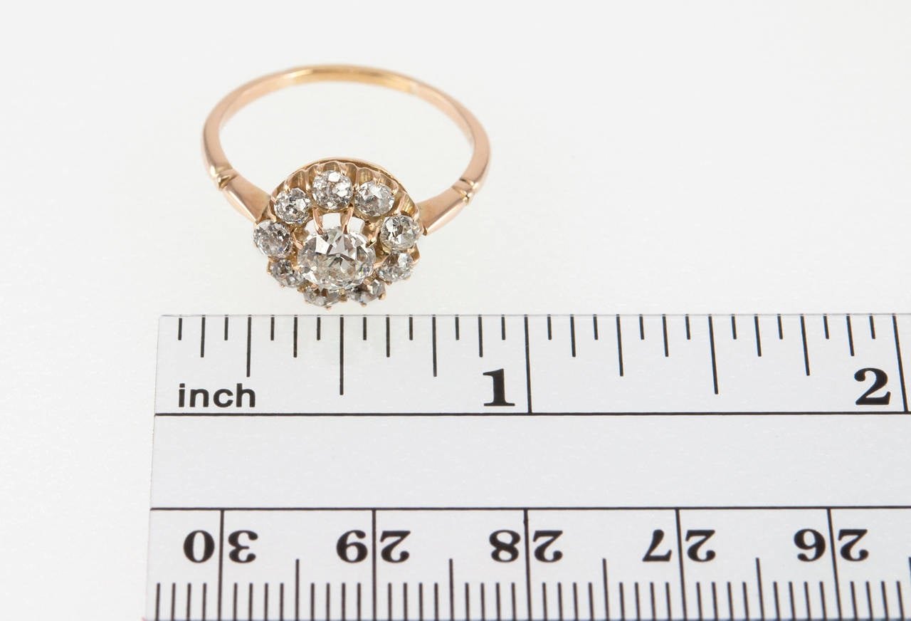 This beautiful Victorian cluster ring features an Old European Cut 0.65 carat       I-SI2 (EGL) diamond center with eight Old European Cut diamonds surrounding it, which total approximately 0.80 carats in diamond weight and set in 18 karat yellow