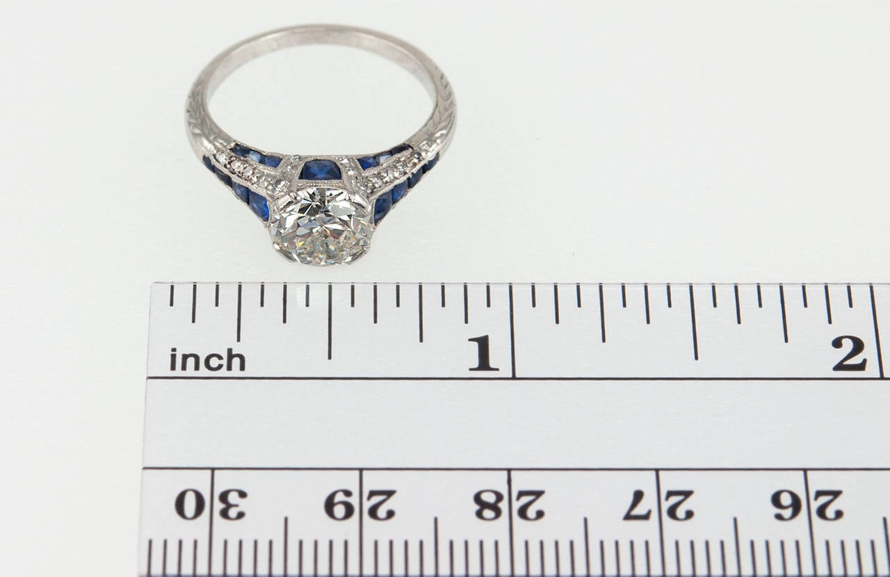 A stunning Art Deco engagement ring, which features a 1.40 carat I-SI1 (EGL) diamond set in platinum with bright blue calibre cut sapphires along the gallery that peak out from all angles of the ring. Circa 1920s. 

Currently a US size 6 and