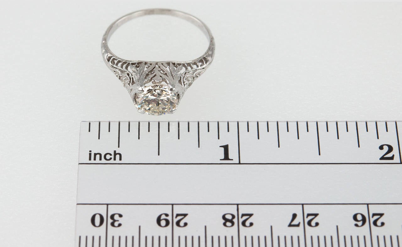 This Edwardian platinum engagement ring features a 1.09 carat K-SI1 (EGL) diamond and is decorated by airy, beautiful open-work and filigree along with two small round diamonds on the sides. Circa 1915. 

Currently a US size 6.25 and easily