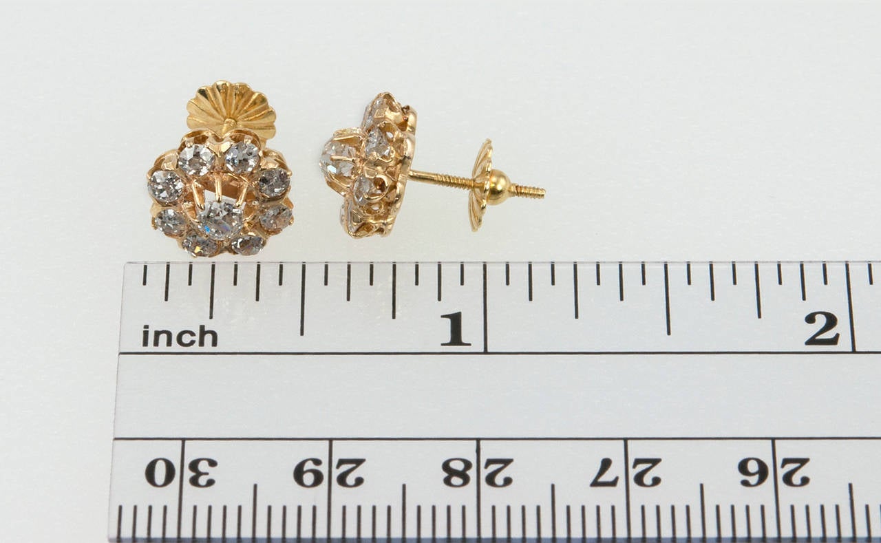 Beautiful Victorian diamond cluster earrings with 18 Old Mine Cut diamonds, approximately 1.50 carats in total diamond weight, set in 18 karat yellow gold. Circa 1890s with the screw back posts added later on. 

Earrings measure approximately 0.43