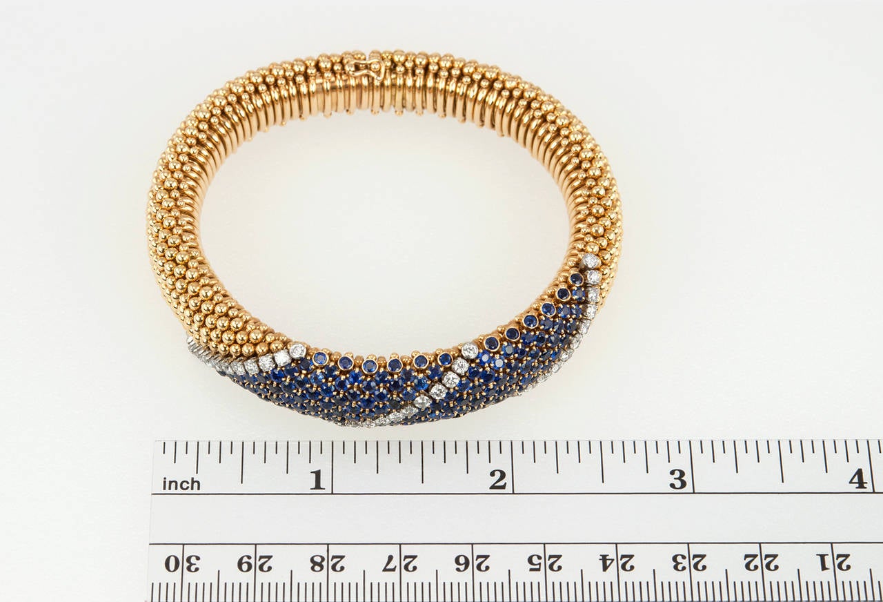 Van Cleef & Arpels flexible tubular bracelet in 18 karat yellow gold and platinum with 156 sapphires and 39 diamonds (approximate total diamond weight is 1.56 carats).  Circa 1960s. A very chic and comfortable bracelet to wear!

The bracelet