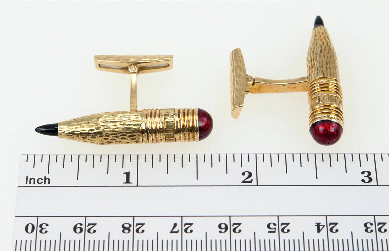 David Webb gold pencil french cufflinks in 18 karat yellow gold with red enamel as the eraser top and black onyx as pencil lead. Circa 1980s. 

Cufflinks measure approximately 0.32 inches in width and 1.52 inches in length.