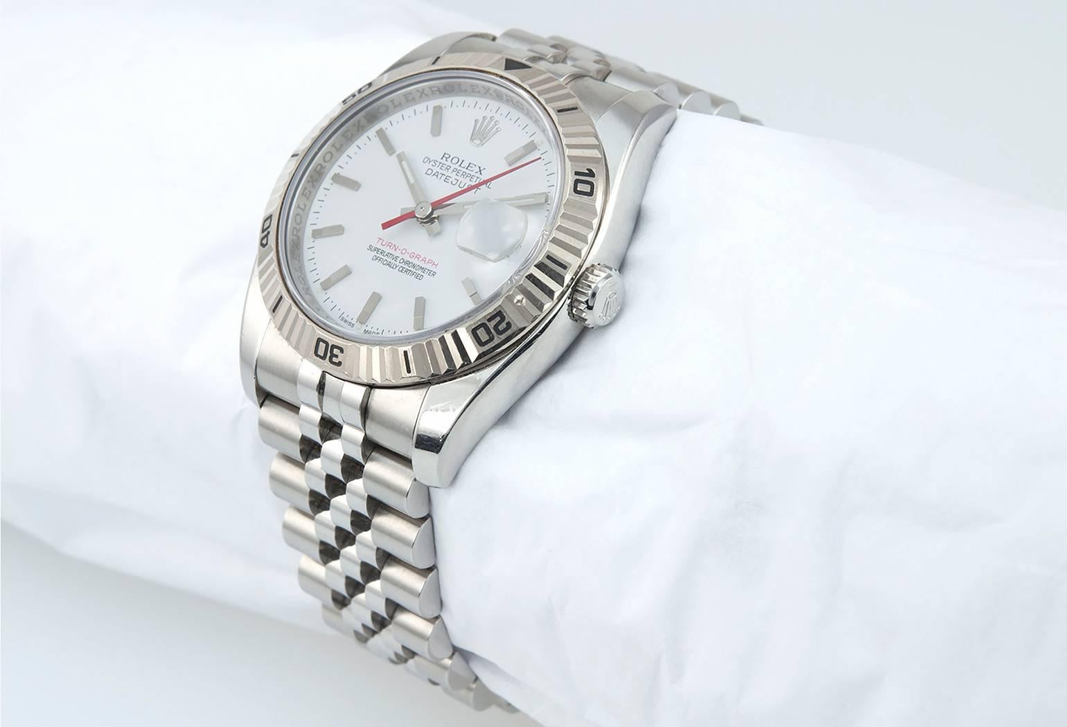 Rolex DateJust Turn-O-graph watch in stainless steel reference 116264. This Rolex features a 18 karat white gold fluted bezel, sapphire crystal, white dial with a red date and red seconds hand, a locking waterproof crown, stainless steel case, and a