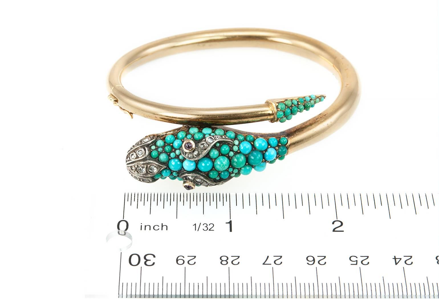 A vintage dragon bangle bracelet from circa 1950s.  This bracelet is 19 karat yellow gold with Portuguese hallmarks.  It features a dragon head with turquoise cabochons in a range of light blues and greens with garnet cabochon eyes and 21 rose cut