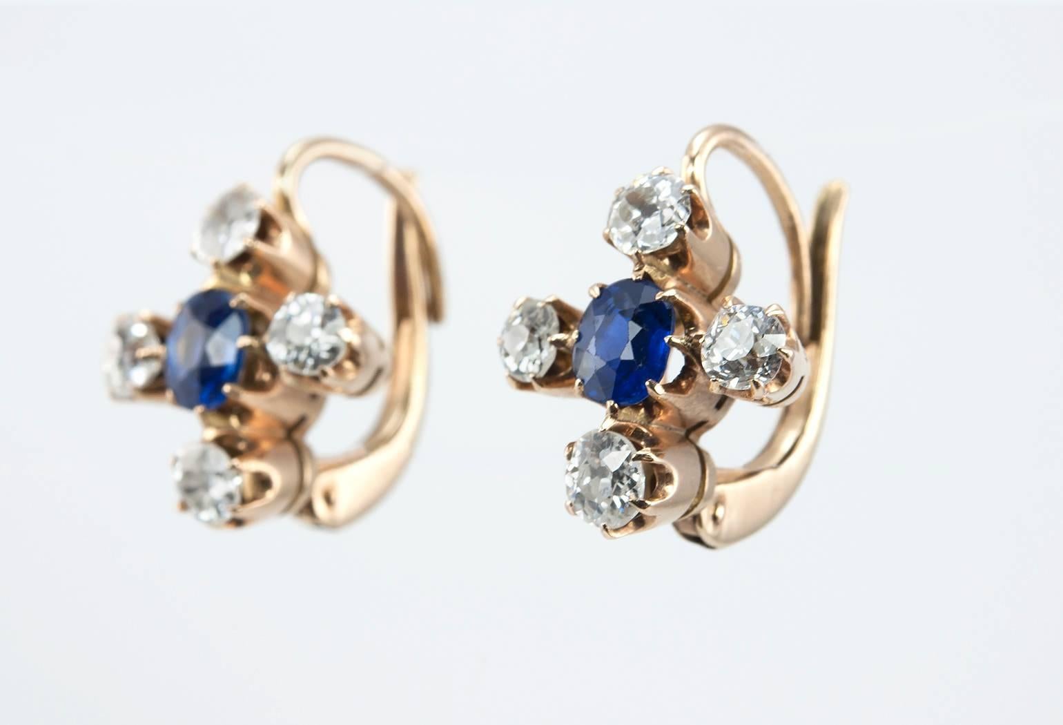 Sapphire and diamond drop earrings in 14 karat rosy/yellow gold with Russian hallmarks, circa 1900.  These beautiful earrings feature 2 sapphires at the center, approximately 0.70 carats total, with 8 old cut diamonds surrounding the sapphire for a
