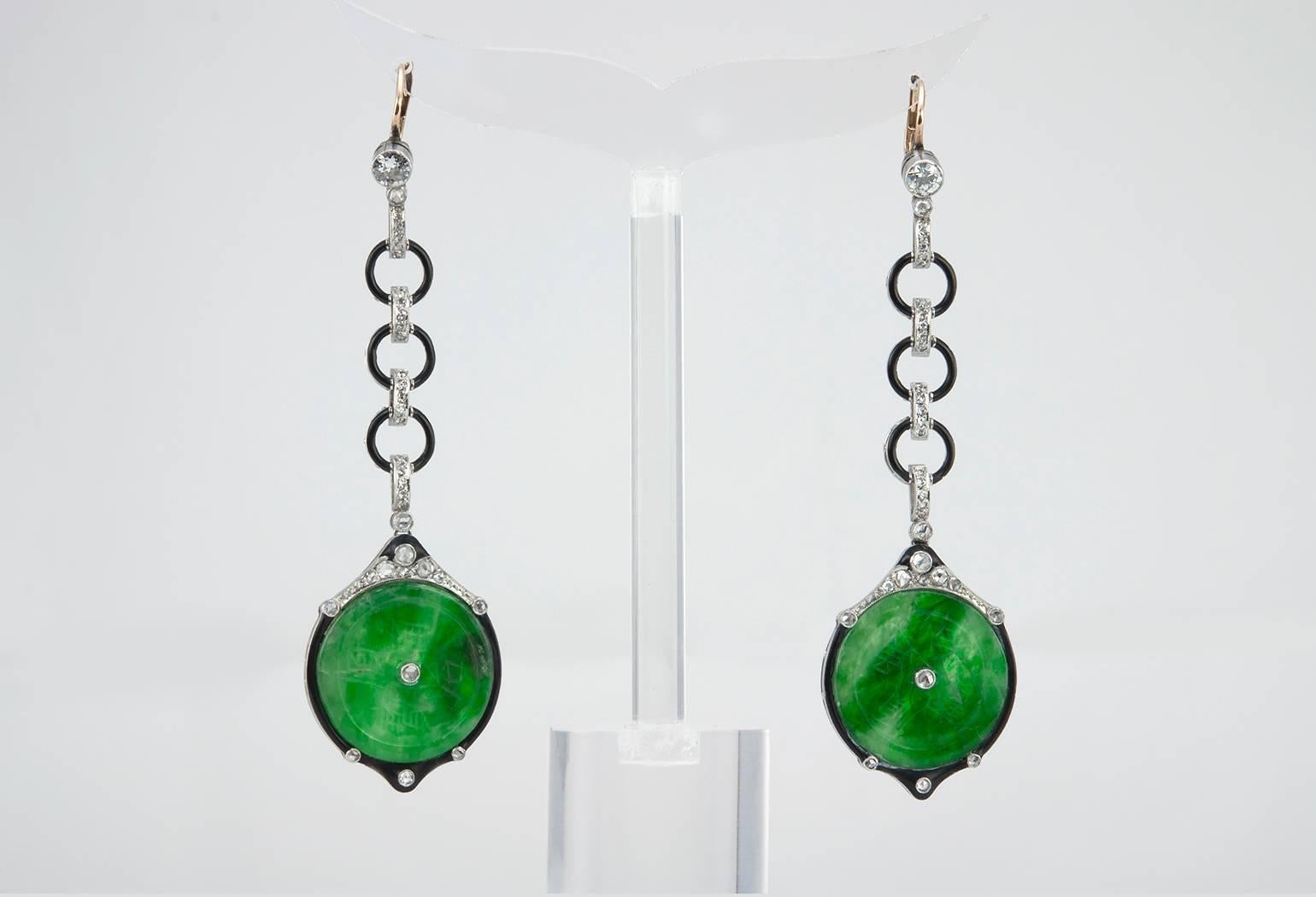Gorgeous platinum Edwardian dangle earrings!  These earrings feature a 20 mm carved jade disc with black enamel detailing and rose cut diamonds.  The top of the earrings are finished with an Old European Cut diamond approximately 0.20 carats.  Circa