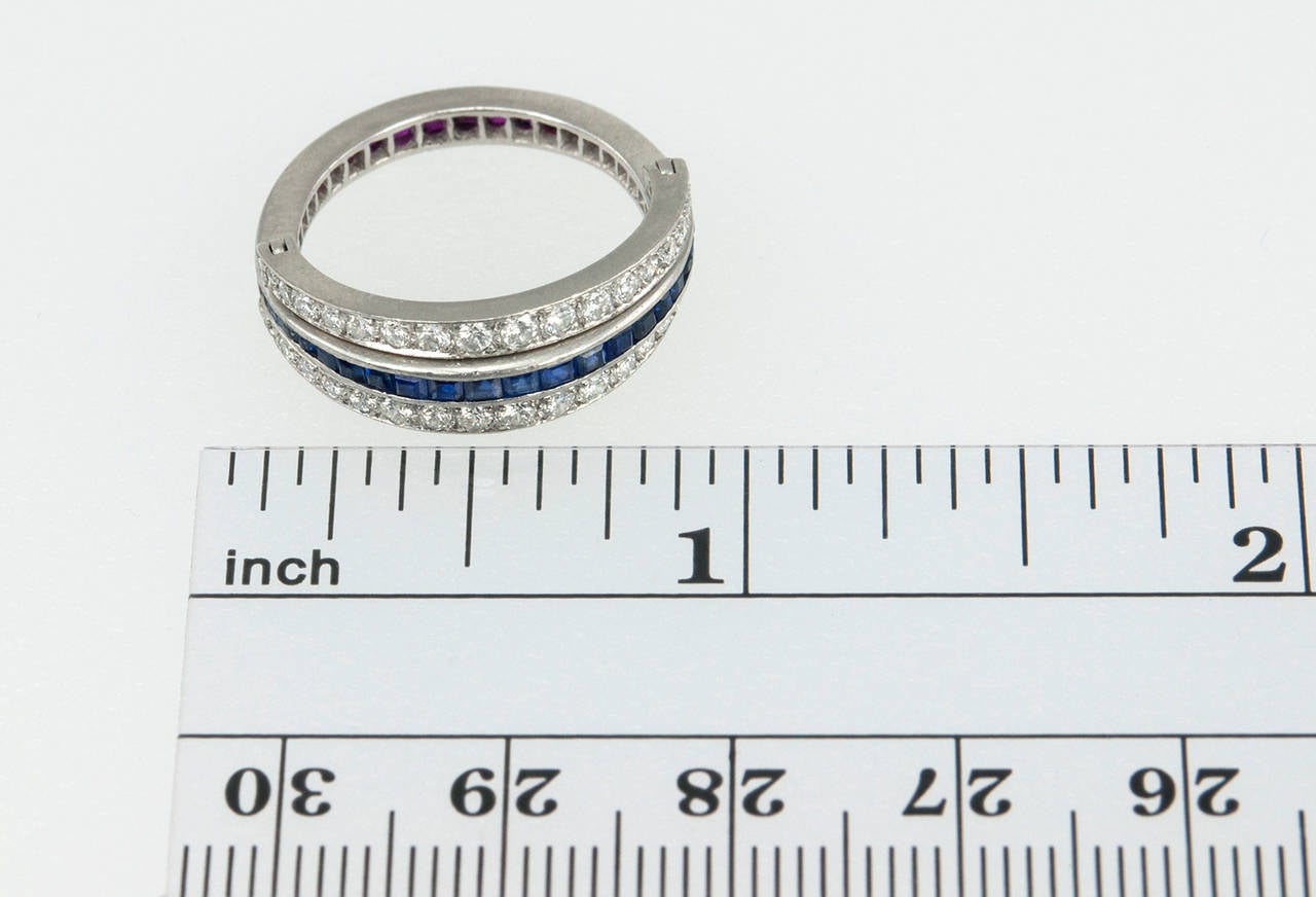 A very cool Art Deco flip band ring featuring diamonds, sapphires, and rubies set in platinum. This ring has two rows of thirty-four brilliant cut round diamonds set in a bead setting with the total diamond weight approximately 0.50 carats. The