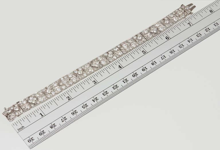 Platinum Art Deco diamond bracelet set with lively Old European Cut diamonds weighing a total of 11 carats. Each bracelet link features a geometric pattern with delicate openwork and millegrain set diamonds. The diamonds range in color from H-I and