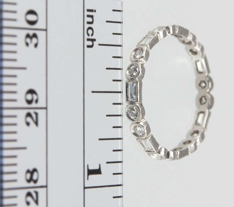 This platinum eternity band features 7 diamond baguettes and 14 round brilliant cut diamonds from the 1940s. Size 6 and cannot be sized.