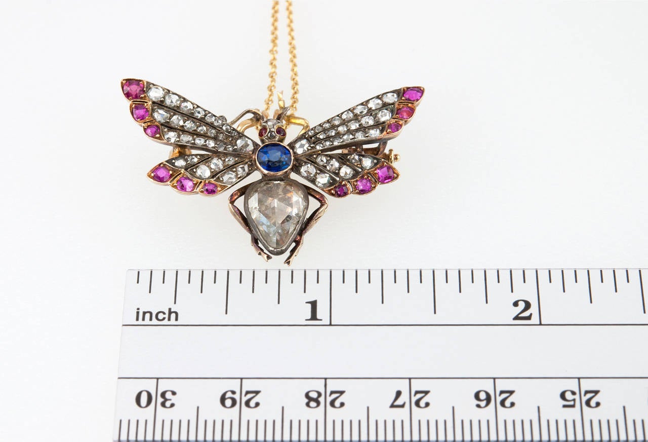 This stunning Victorian butterfly pendant also has a pin on the back to wear as a brooch as well. It features a large pear shaped rose cut diamond that we believe to be foil backed, approximately 1 carat, along with 58 rose cut diamonds, 14 rubies,