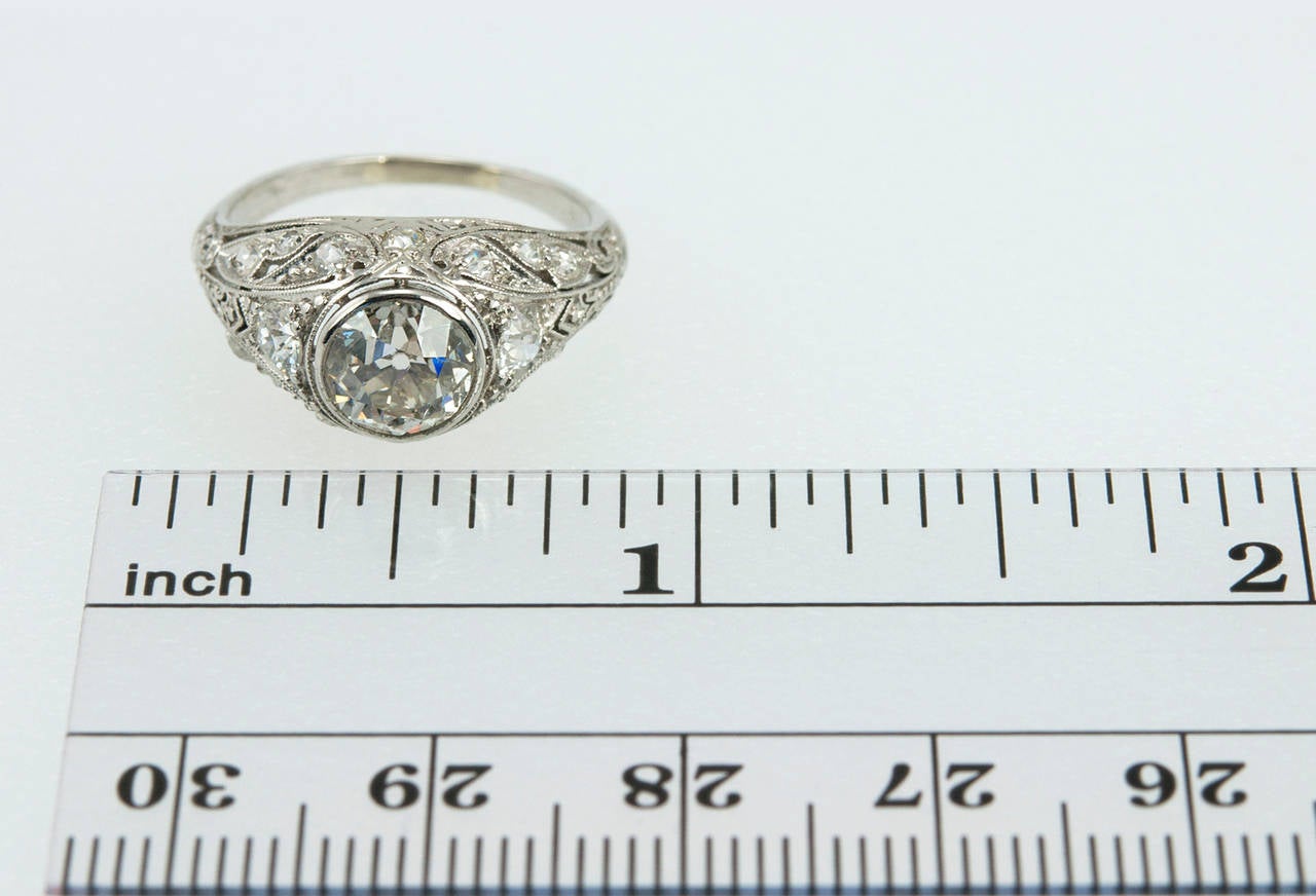 This gorgeous platinum Edwardian ring features a bezel set 1.23 carat H-I SI1 Old European cut diamond center stone and 16 Old European cut diamonds that are F-H color, VS1-SI2 clarity set throughout the ring for a total diamond weight of 0.53