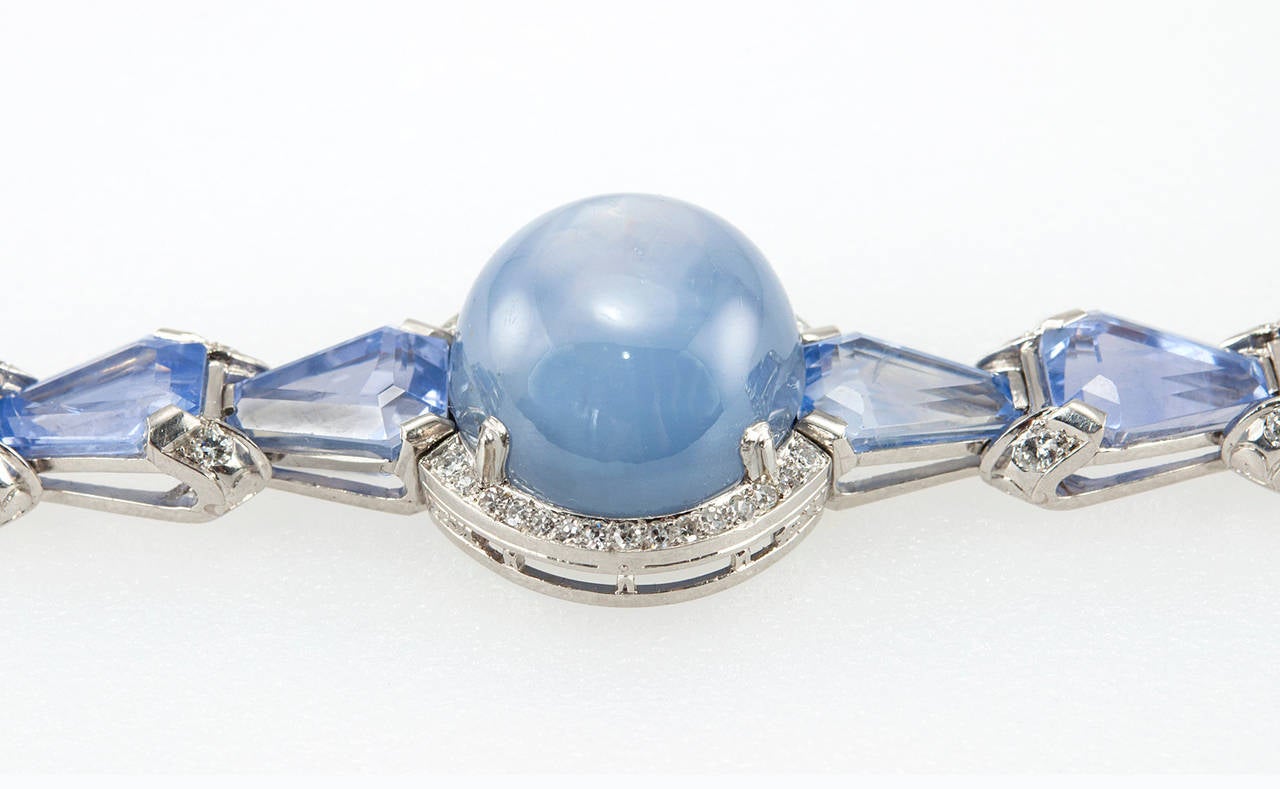 A stunning Oscar Heyman Art Deco bracelet! This platinum link bracelet features a center 39.60 carat medium blue star sapphire cabochon and 15 step cut sapphires which together weight 44.03 carats. The bracelet is further accented by 62 round