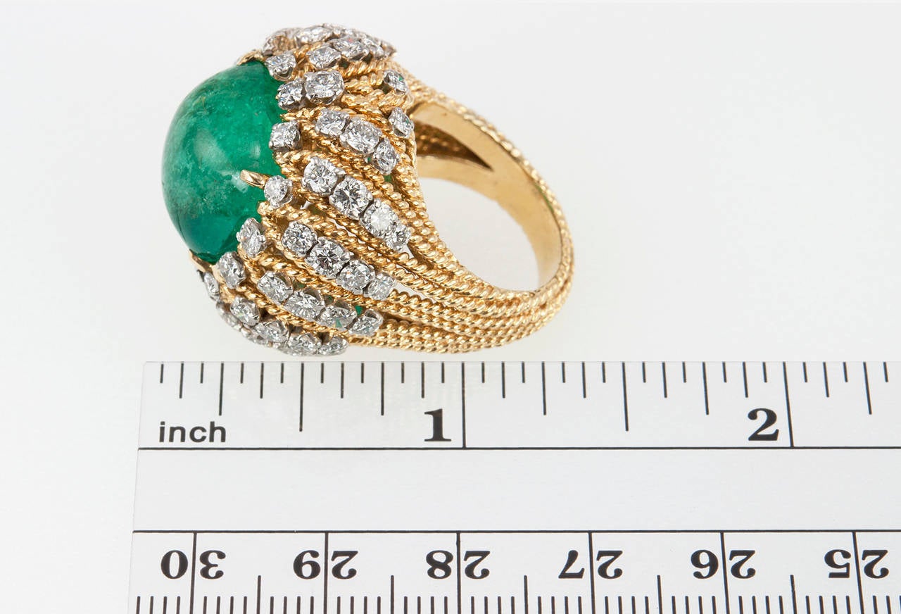 So '70s chic! This ring features a 17.59 carat natural, untreated emerald in a cabochon setting surrounded by 72 round brilliant cut diamonds, which totals approximately 3 carats in diamonds, and 18 karat yellow gold. Circa 1970s. 

This ring is