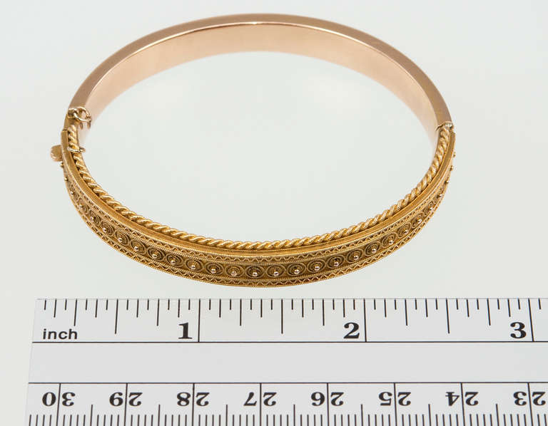 Victorian Etruscan Revival bangle bracelet in 14 karat yellow gold with delicate gold granulation.. This bracelet looks great alone and also stacked with other bangles since it is 10mm in width. The inside diameter of the bangle is 6.75 inches when