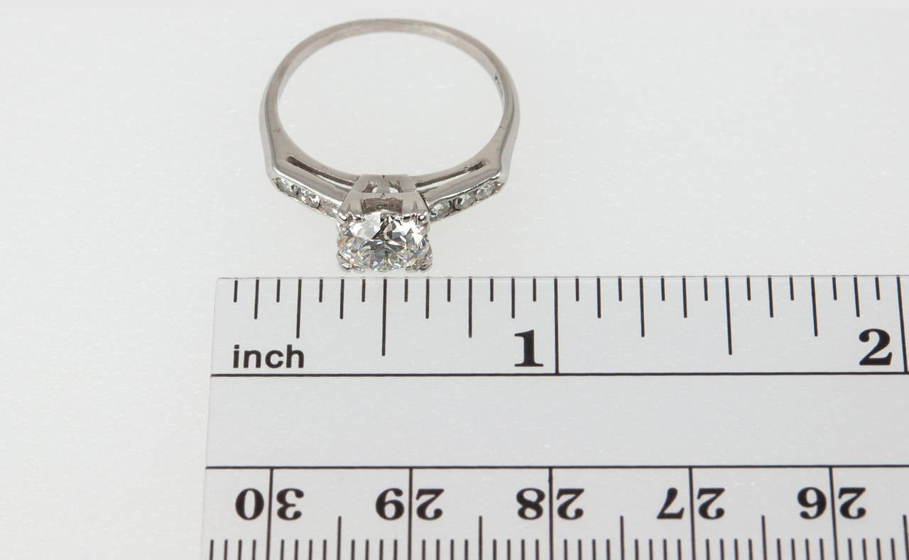 Classic simplicity at it's finest! This ring features a 1.28 carat H-VVS2 (GIA) round brilliant center diamond set in platinum with three round single cut diamonds on each shoulder (approximately 0.15 carats total diamond weight for the 6 single