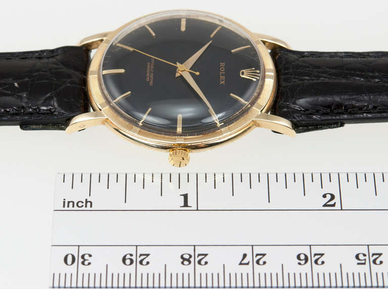 A chic Rolex 14k yellow gold chronometer wristwatch with matte black dial and gold dauphine hands, Ref. 8952, circa 1945. 
18-jewel manual-wind movement, 35mm circular case with textured bezel.

This watch includes a one year warranty from the