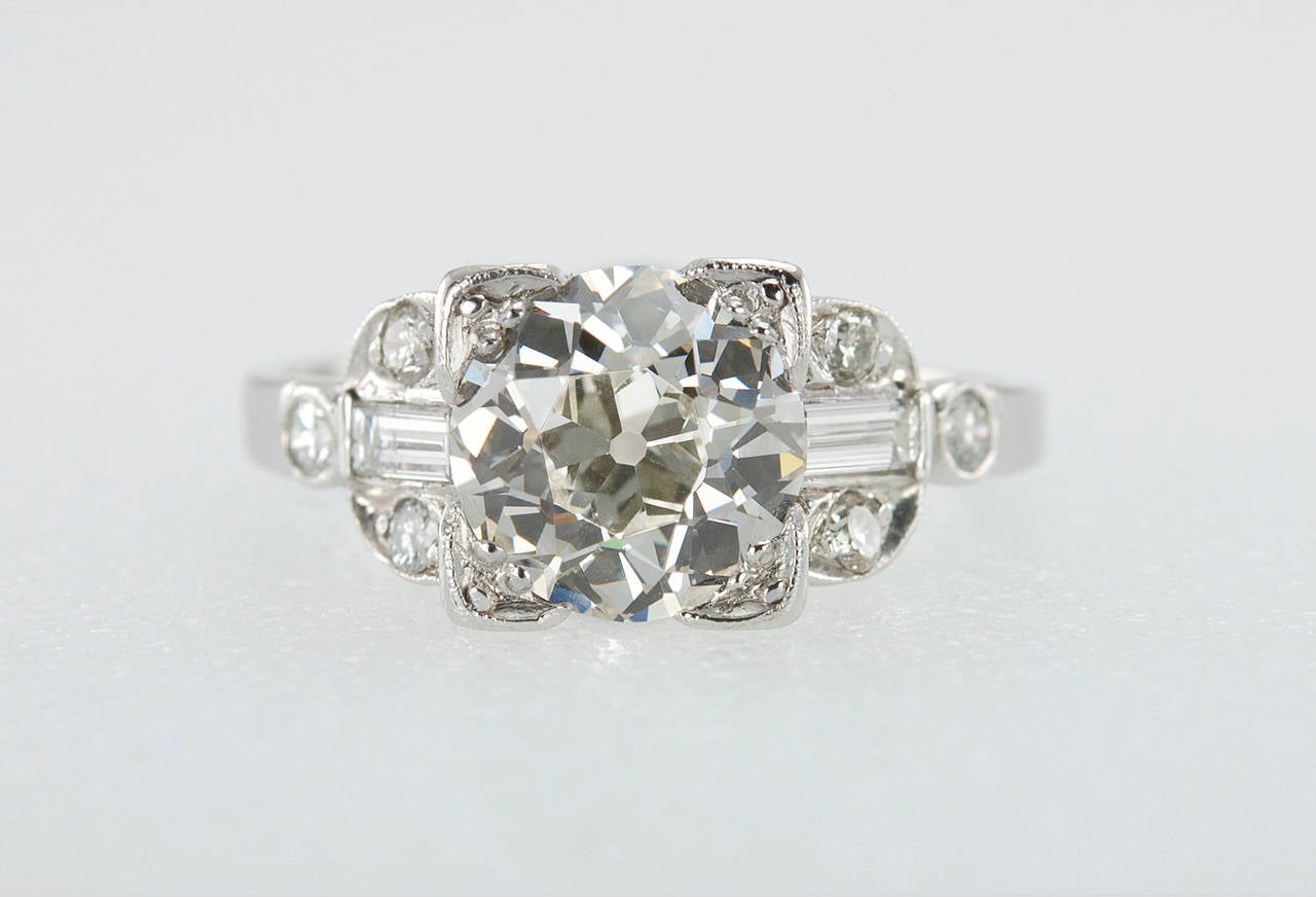 A gorgeous Art Deco platinum engagement ring featuring an Old European Cut 1.86 carat diamond center that is K in color and VVS2 in clarity (per GIA) set in a square setting. Each shoulder of the ring is accented by a diamond baguette and 3 small