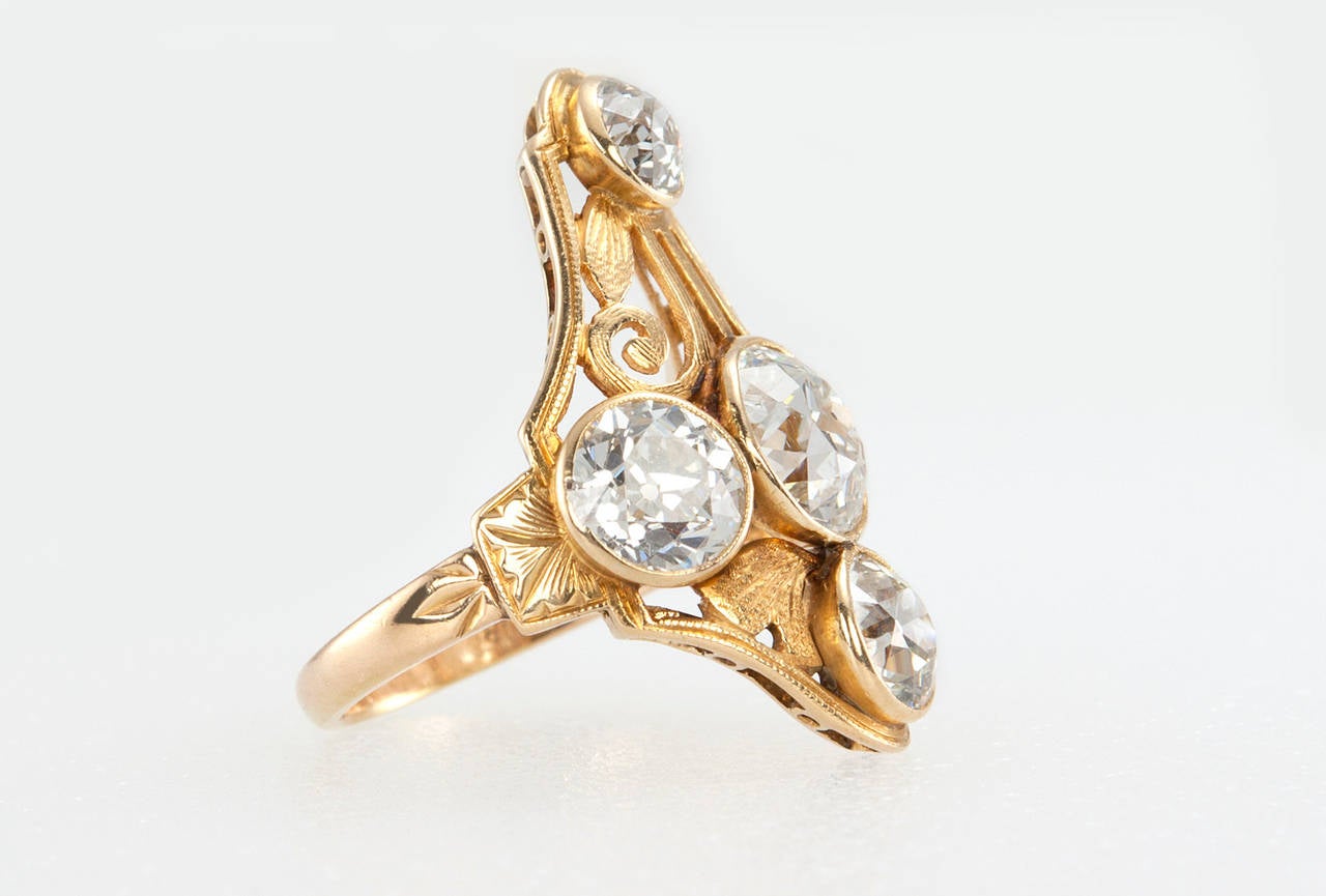 This stunning Arts & Crafts 18 karat yellow gold ring features a 1.82 carat Old European Cut diamond that is F-G in color and SI1 in clarity along with four other Old European Cut diamonds that are F-G in color and VS1-SI2 in clarity with the total