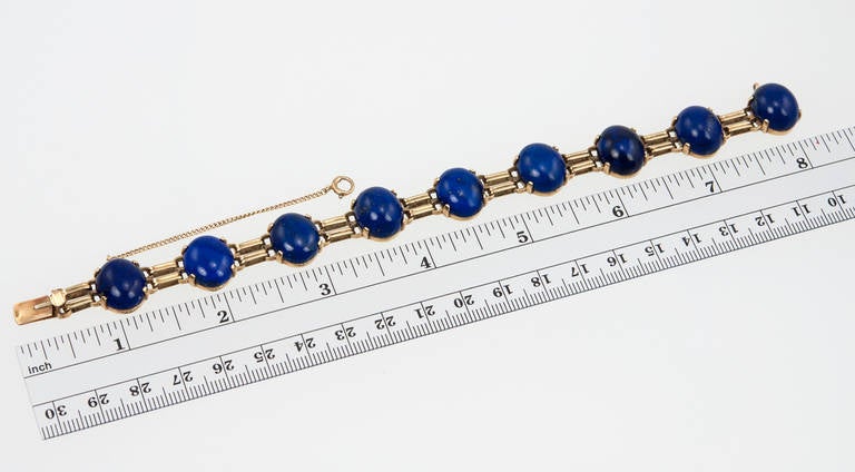 This retro link bracelet features nine lapis lazuli cabochons with alternating gold links in 14 karat yellow gold, circa 1940s. 

Interior diameter of bracelet is approximately 7.5 inches.