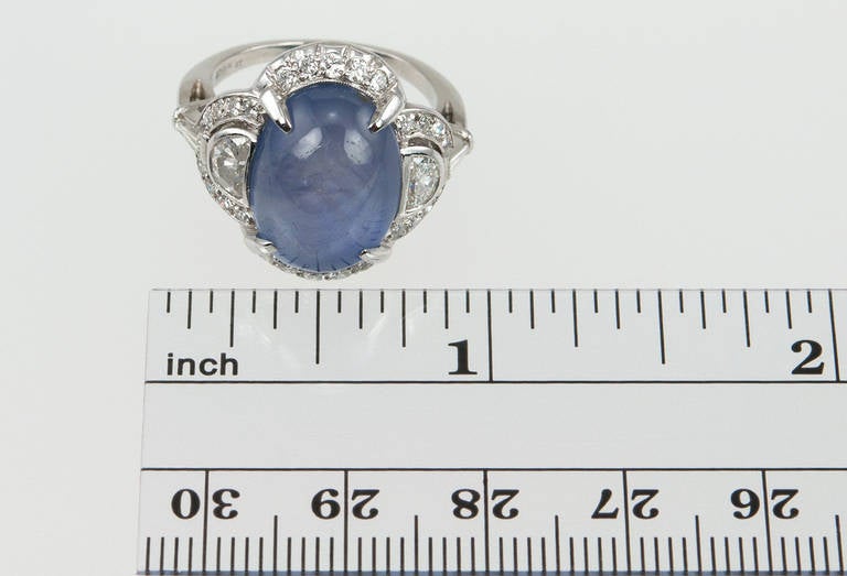 A beautiful Art Deco cabochon sapphire ring set in platinum with two side half moon diamonds, which total approximately 0.30cts of diamonds along with 26 additional small round diamonds totaling approximately 0.50cts of diamonds, circa 1930s. Simply