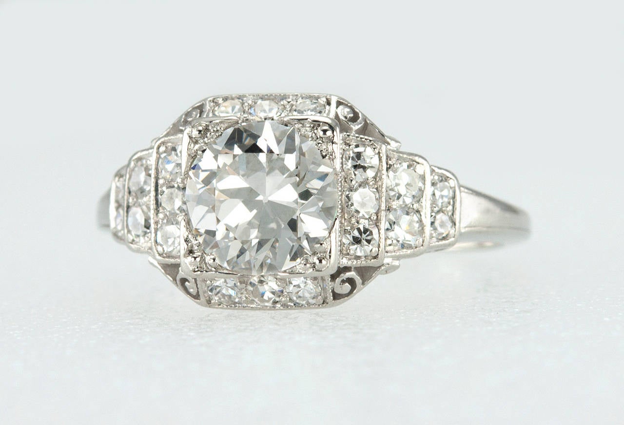 A beautiful Art Deco engagement ring featuring a 1.04 carat Old European Cut diamond that is G in color and VS1 in clarity (per EGL certificate). The center stone is set in a square mounting on an overall step mounting that is set with twenty