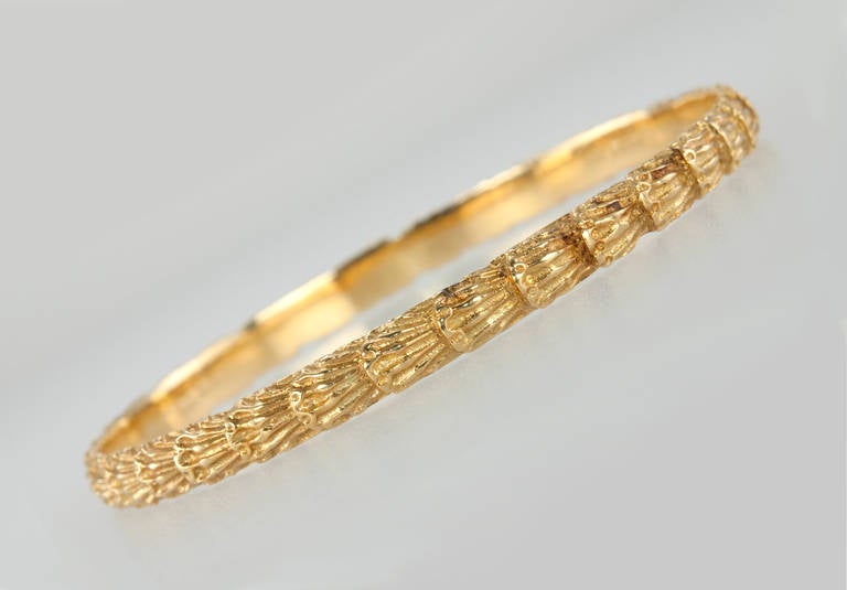 This M Buccellati thin bangle bracelet features a repeating, textured gold design in 18 karat yellow gold- great to wear alone or stacked with others! Circa 20th Century and signed M Buccellati.