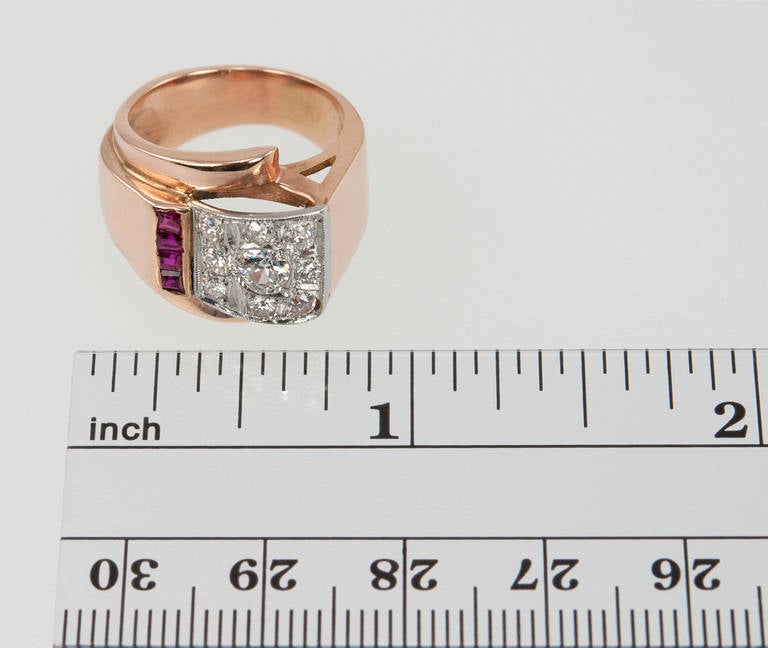 This very cool retro ring features diamonds and rubies set in 14 karat rose gold. The center round diamond is approximately 0.25 carats with 8 round brilliant diamonds, totaling approximately 0.40 carats of diamonds. Circa 1950s.
Currently a US