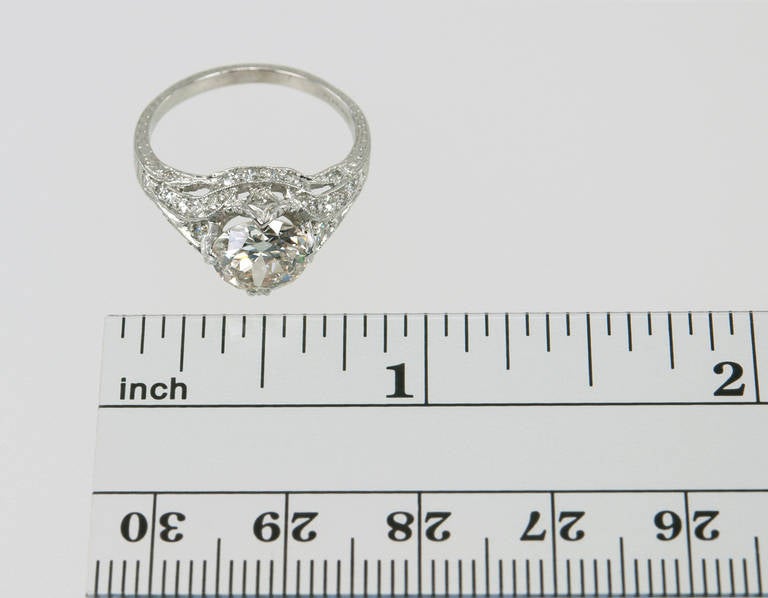 A beautiful late Edwardian/early Art Deco engagement ring that features the best of both styles: a 1.53ct I-SI1 (EGL) diamond set in a platinum raised setting with lovely milegraining, pierced open-work, engraving, geometric symmetry and thirty-two
