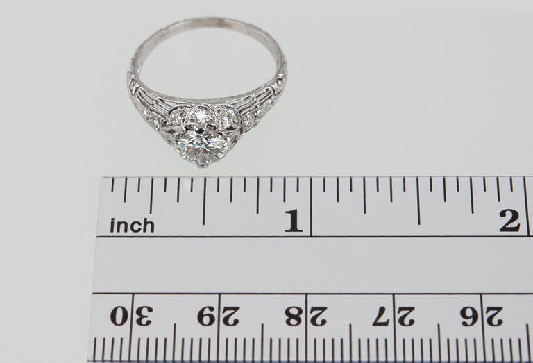 This beautiful Edwardian platinum engagement ring features a 0.70 carat F-VS2 (EGL) diamond center stone along with eight small round diamond accent stones placed around the center stone and sides that gives added sparkle. This ring is feminine and