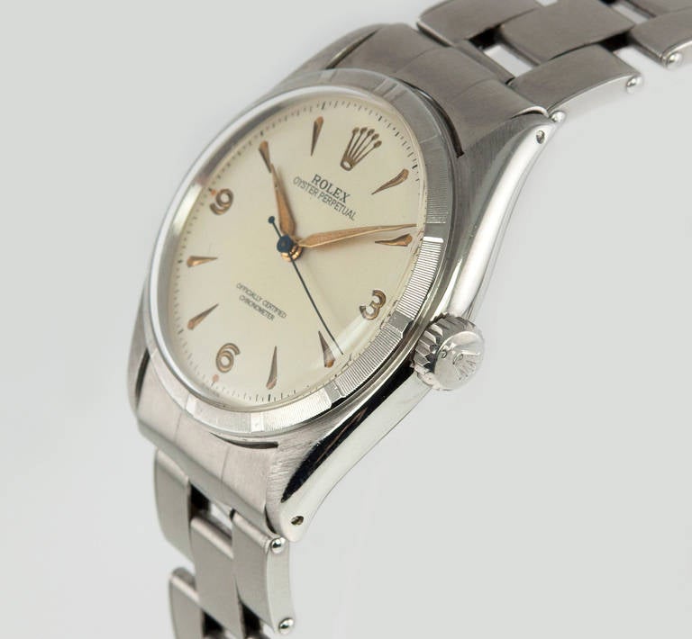 Rolex stainless steel Oyster Prepetual wristwatch, Ref. 6082. This Rolex watch features a 3, 6, 9 silveedr satin dial, engine-turned steel bezel, an automatic movement, plastic crystal, and waterproof crown. The case measures 34mm. Circa