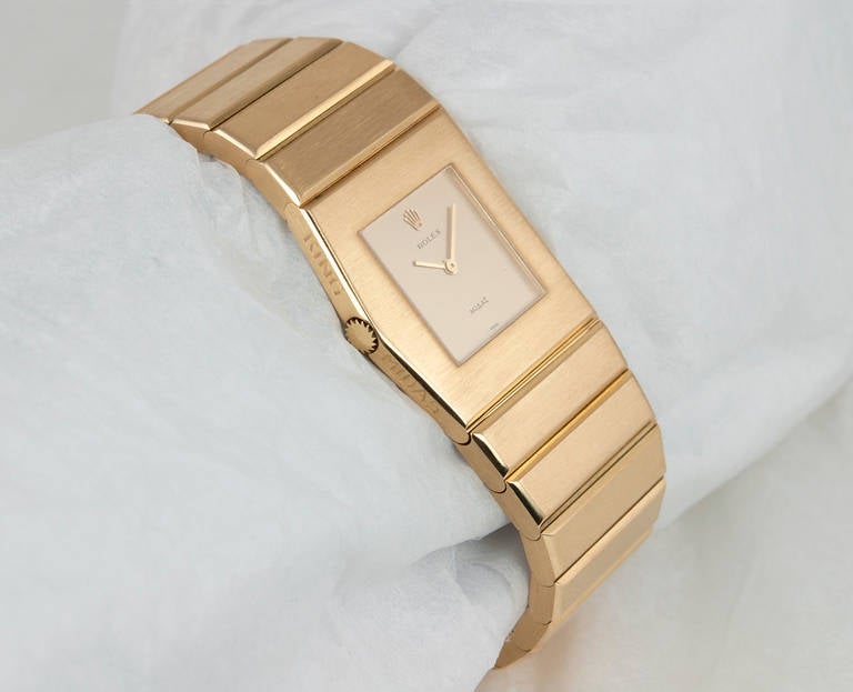 Rolex 18k yellow gold King Midas wristwatch, circa 1967. This unusual Rolex watch has a sapphire crystal and asymmetric case with original champagne color dial. The bracelet on this watch is a heavy tapering style bracelet, this watch features a