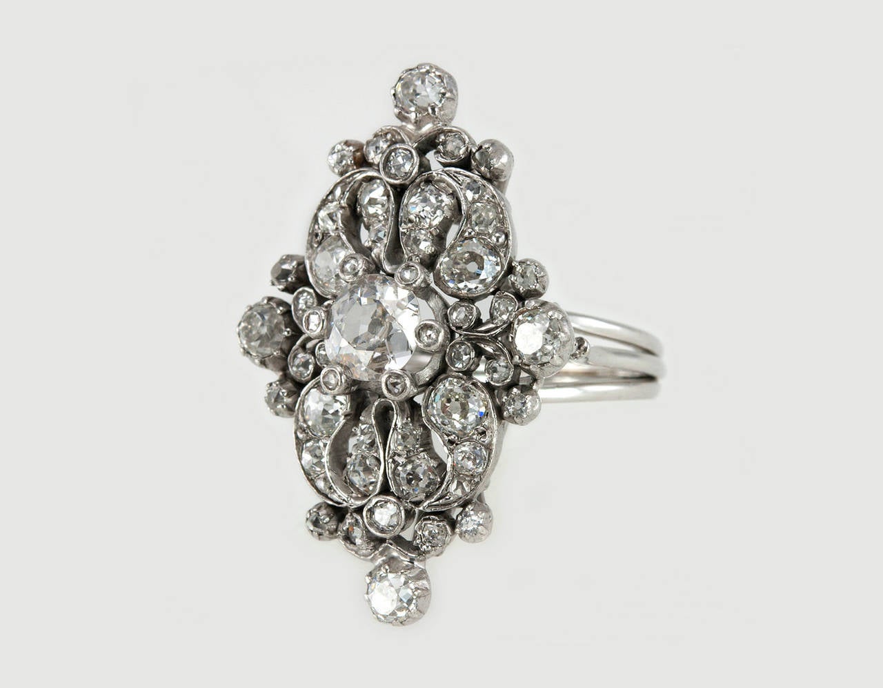 This show-stopping diamond ring started off its life most likely as a brooch circa 1900s and later around the 1960s was made into a ring. The diamonds are very old and feature an Old Mine Cut center stone diamond approximately 0.85 carats L-SI2