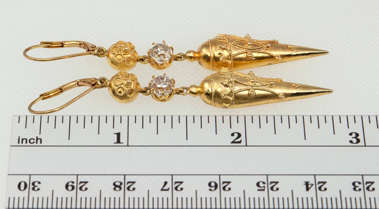 These Victorian earrings are made in the Etruscan Revival style in 18 karat yellow gold and feature two Old Mine Cut diamonds which are each approximately 0.50ct L-M in color and SI in clarity, circa 1890s. These fantastic earrings are light and