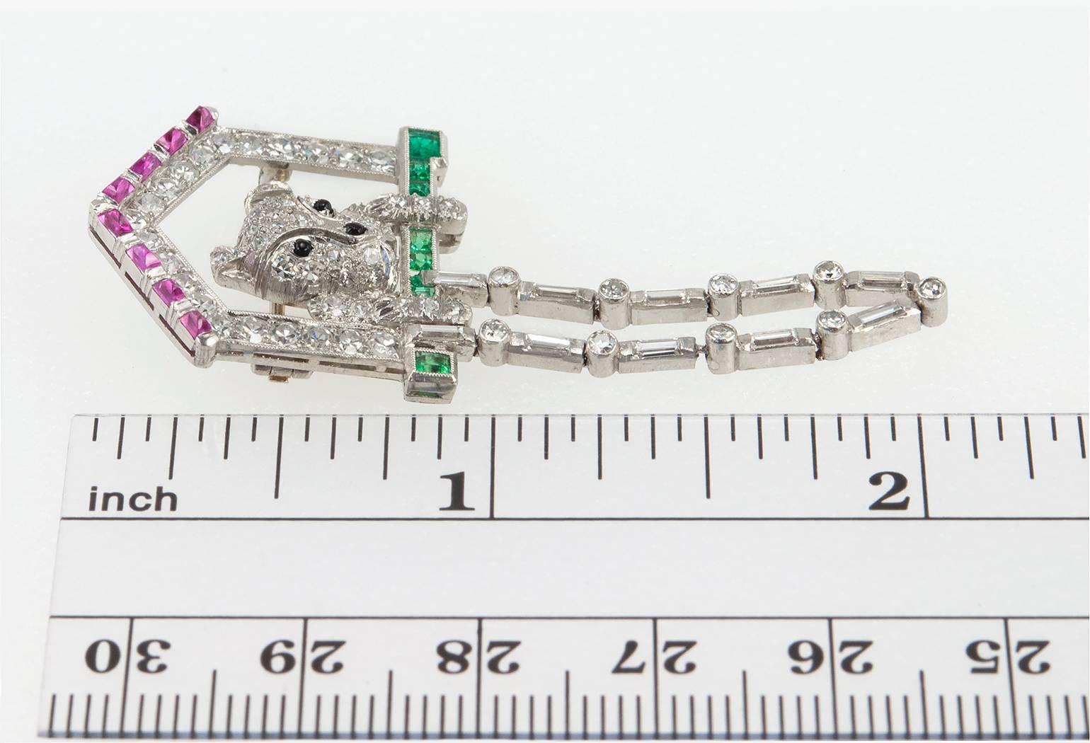 
An adorable dog in a doghouse brooch!  This whimsical platinum brooch features a diamond dog in a doghouse with emeralds and rubies on a diamond leash with approximately 2 carats in total diamond weight.  Circa 1930s.

The brooch measures