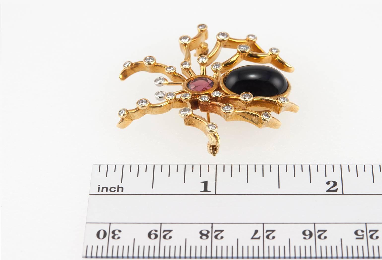 Tiffany & Co. Paloma Picasso spider brooch in 18 karat yellow gold.  This fantastic brooch features onyx and tourmaline for the spiders body with 26 round bezel set diamonds on the spider's legs. Circa 2000s.