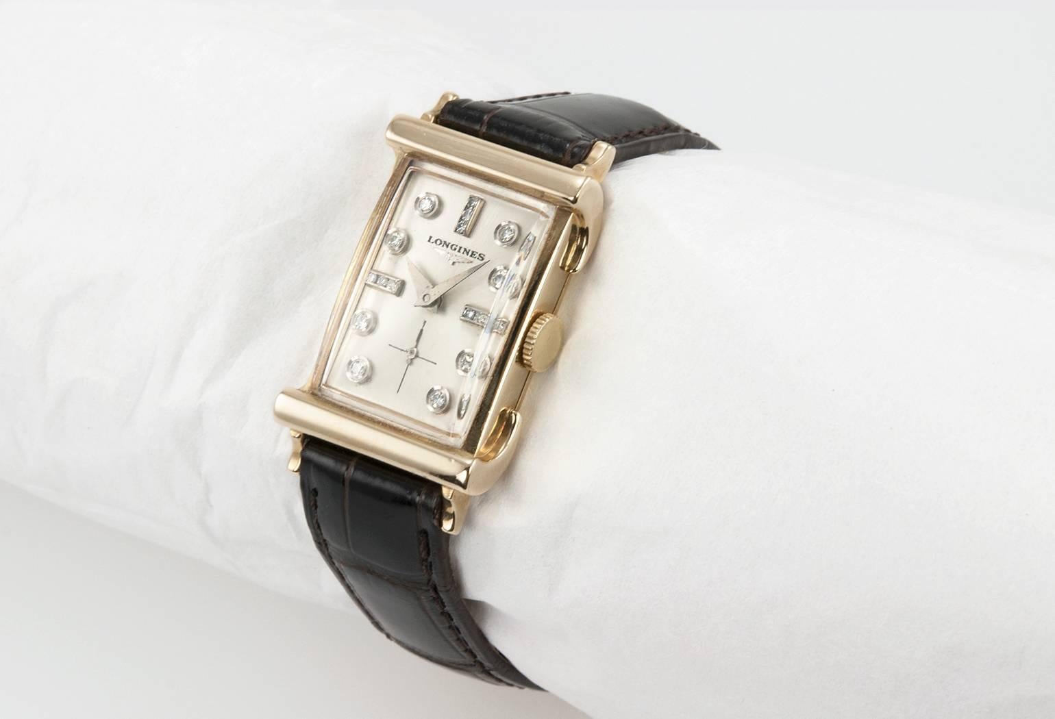 Longines rectangular dress watch in 14 karat yellow gold with a diamond dial. This Longines watch features a silver colored dial with diamond markers and has a 17 jewel movement on a new dark brown Alligator leather strap with a new gold-tone