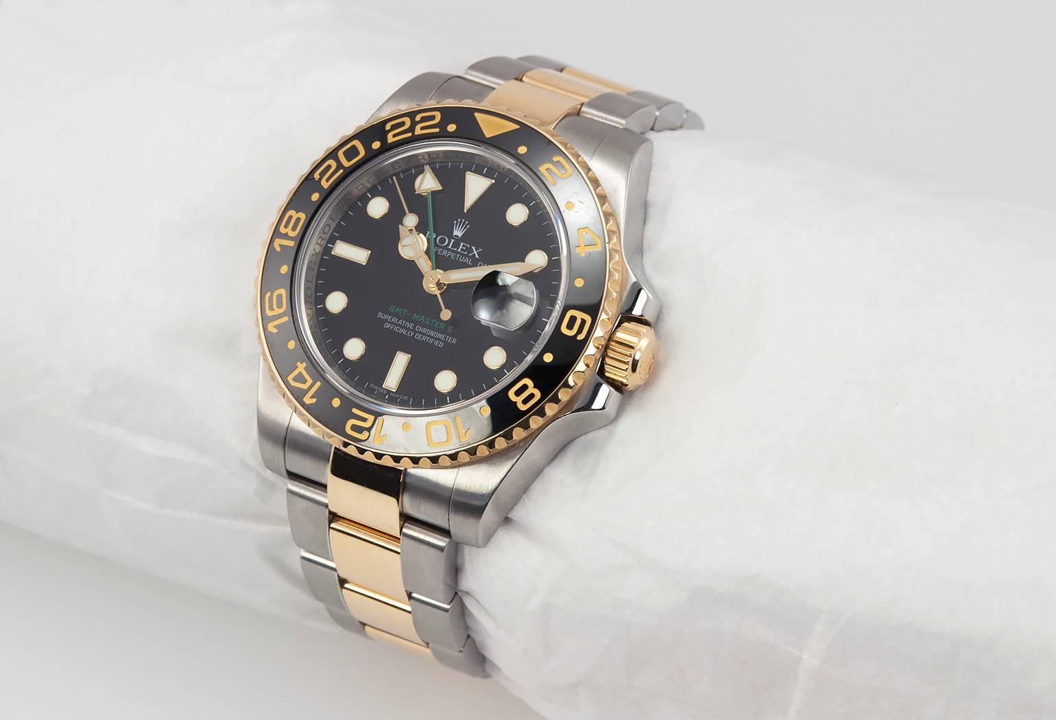 Rolex GMT wristwatch in 18 karat yellow gold and stainless steel, reference 116713. This Rolex watch features a rotating bi-directional black ceramic bezel, an automatic 3186GMT movement with date and two time zone, quickset, scratch-resistant