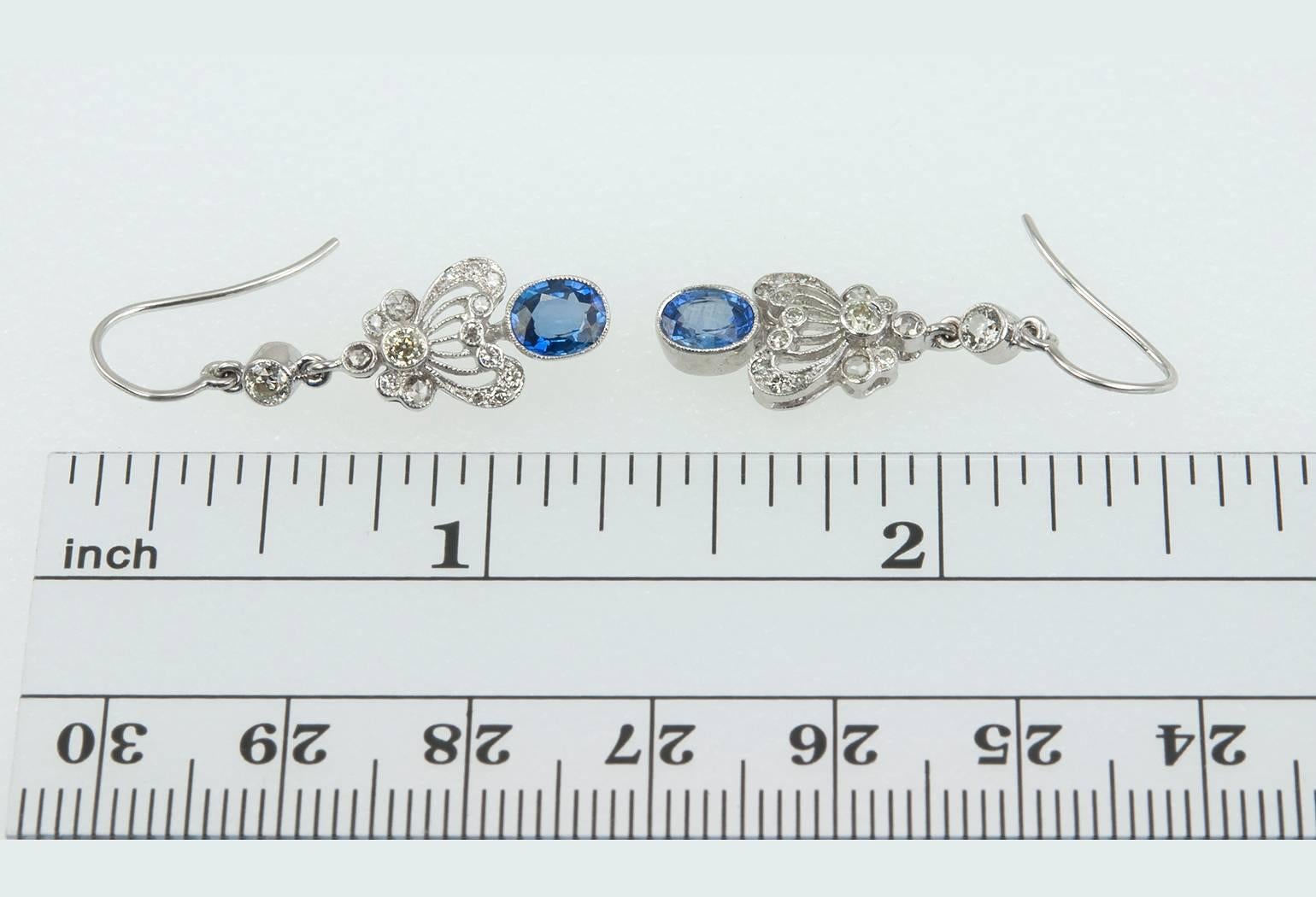 These pretty diamond and sapphire earrings were made in the Edwardian style.  They feature Old European Cut diamonds in a bezel setting with oval sapphires in 18 karat white gold.  The total diamond weight is approximately 0.40 carats and 0.40