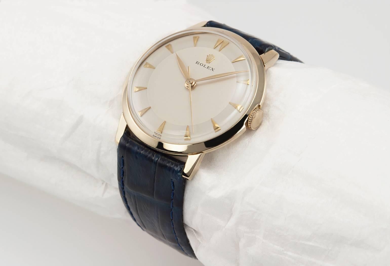 Rolex dress watch in 14 karat yellow gold, reference 0066. This 1960's Rolex watch is simple and chic. It has a 17 jewel mechanical movement, original dial, plastic crystal, with a new blue leather strap. Circa 1968. This case measures approximately