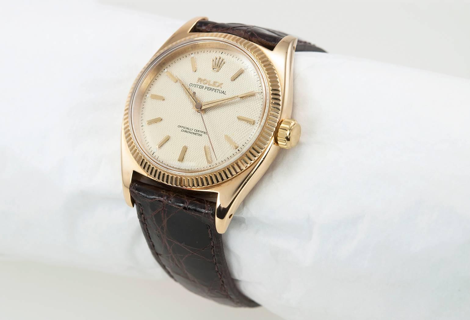 Rolex 18 karat yellow gold Oyster Perpetual wristwatch, reference  6503. This watch features a refinished textured silvered dial with baton style markers, fluted 18 karat yellow gold bezel,  plastic crystal, on a new brown leather strap.  Circa