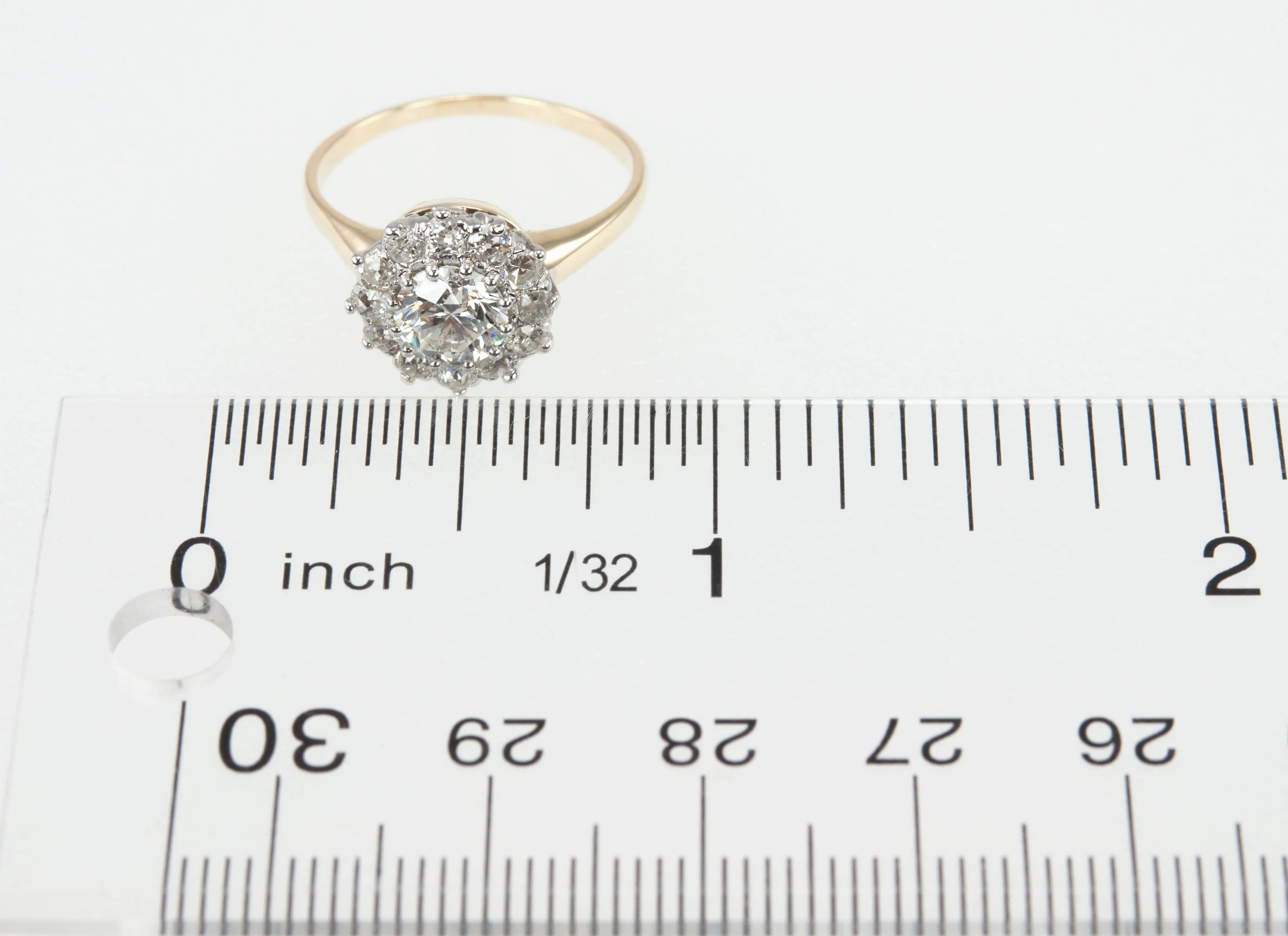 A beautiful, antique diamond cluster ring in platinum topped 14 karat yellow gold. The center diamond is 0.76 carats, E in color and VVS2 in clarity (per EGL certificate).  Surround the center diamond are 12 Old European Cut diamonds, approximately