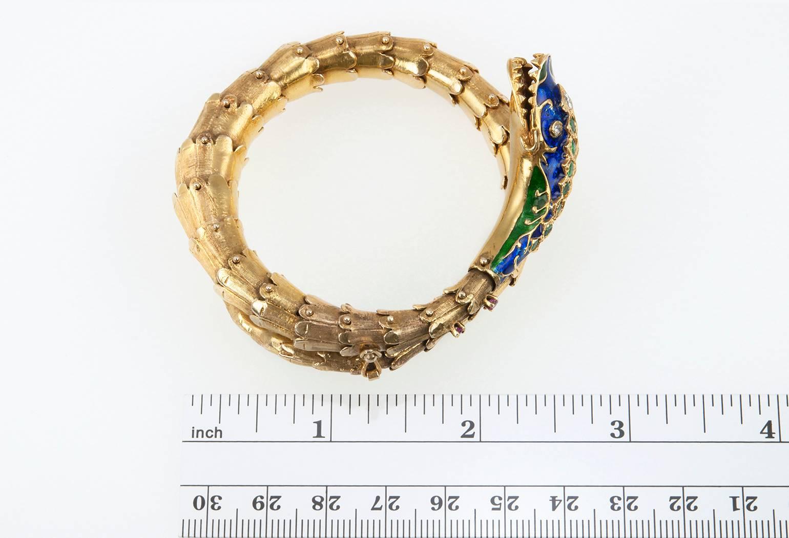
A 1950s snake bracelet constructed in 18 karat yellow gold with blue and green enamel.  The snake's head has 3 diamonds, approximately 0.30 carats in total diamond weight, along with 7 emeralds down it's head and 2 rubies. Fantastic workmanship