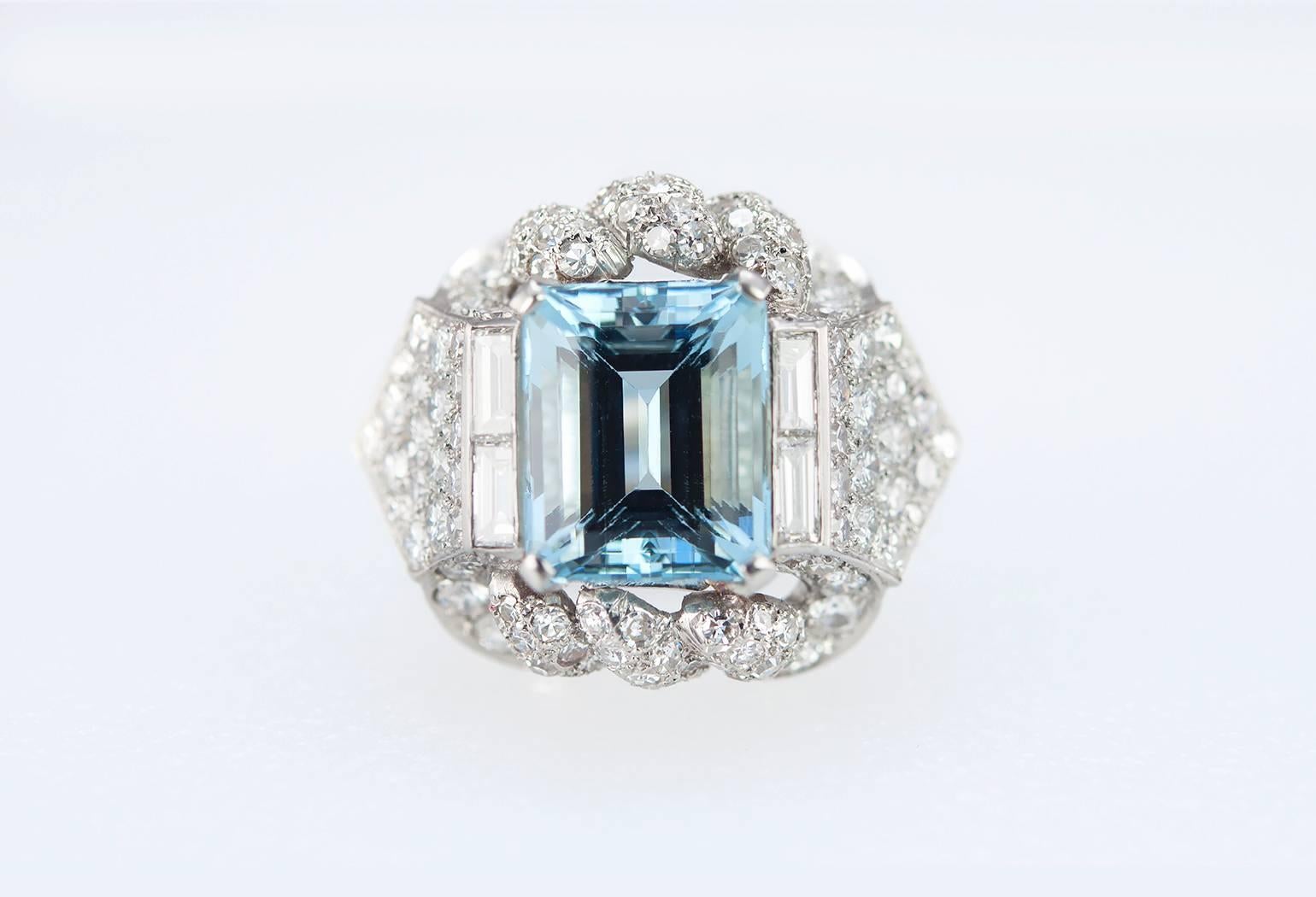 A beautiful 1960s platinum cocktail ring featuring a 5.45 carat aquamarine center surrounded by 4 baguette diamonds and an additional 128 round diamonds set throughout the mounting, approximately 3 carats in total diamond weight. The ring is