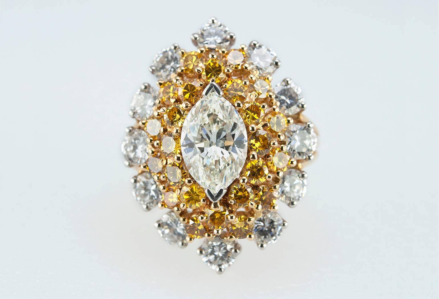 Oscar Heyman vintage diamond cocktail ring in platinum and 18 karat yellow gold from 1968. This ring features a center marquise diamond that is 1.58 carats and surrounded by two rows of 24 round yellow diamonds, which total 1.41 carats in diamond