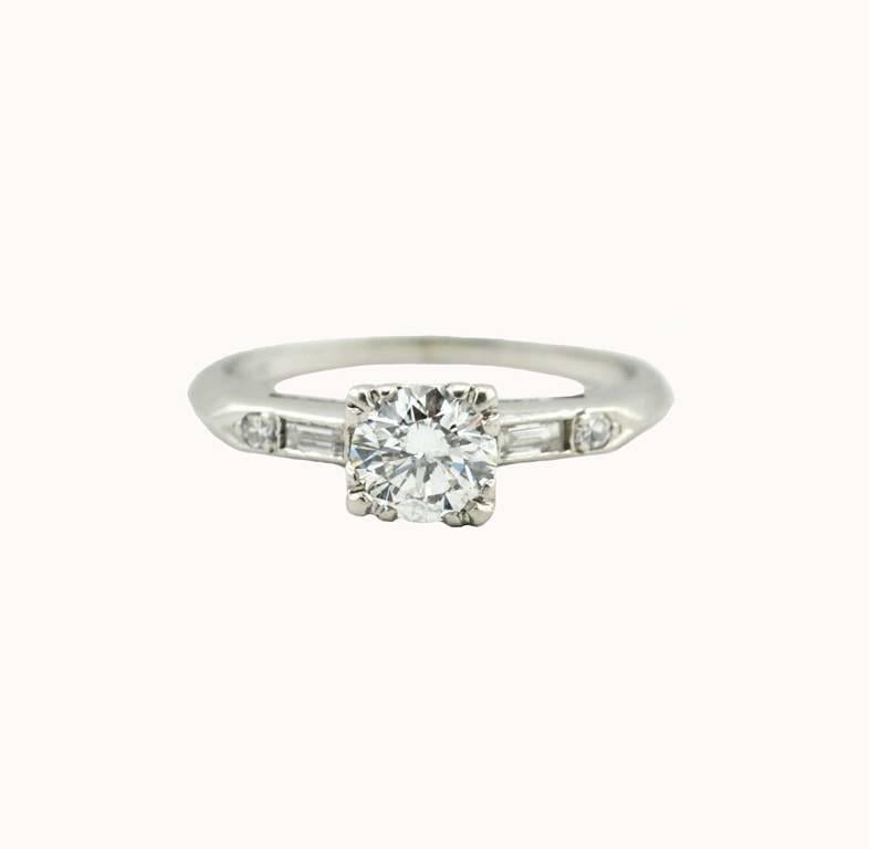 A classic diamond engagement ring from circa 1940.  This beautiful ring features a center transitional cut diamond, approximately 0.70 carats that is I-J in color and I1 in clarity.  The ring is further accented with 2 baguettes and 2 single cut