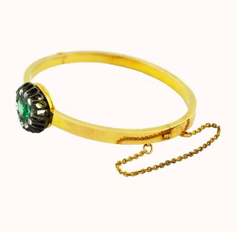 A gorgeous Victorian bangle bracelet in 14 karat yellow gold.  The bracelet features a 1 carat emerald surrounded by 10 rose cut diamonds. Circa 1890.

This bracelet measures approximately 6.5 inches in diameter and 0.15 inches to 0.54 inches in