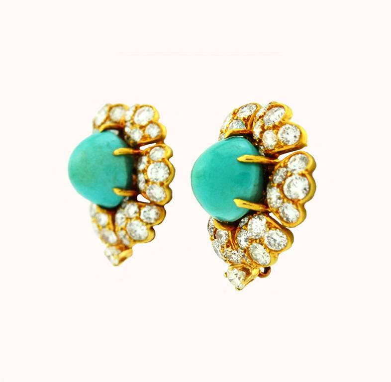 A beautiful pair of David Webb turquoise and diamond gold cluster earrings in 18 karat yellow gold.  These clip-on earrings feature 2 greenish-blue turquoise cabochon at the center of each earring and 74 round cut brilliant diamonds, which total