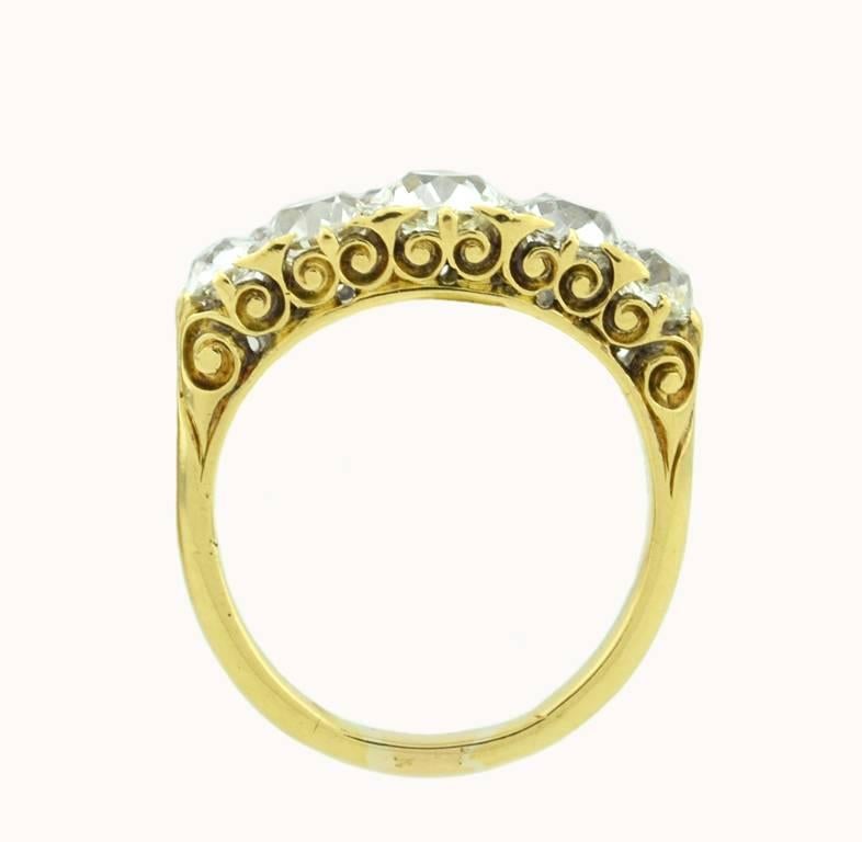 A stunning Victorian five stone diamond ring in 18 karat yellow gold from circa 1890s-1900s. This gorgeous ring features Old Mine Cut diamonds with 8 small rose cut diamonds set in between. The center diamond weighs approximately 0.95 carats. The